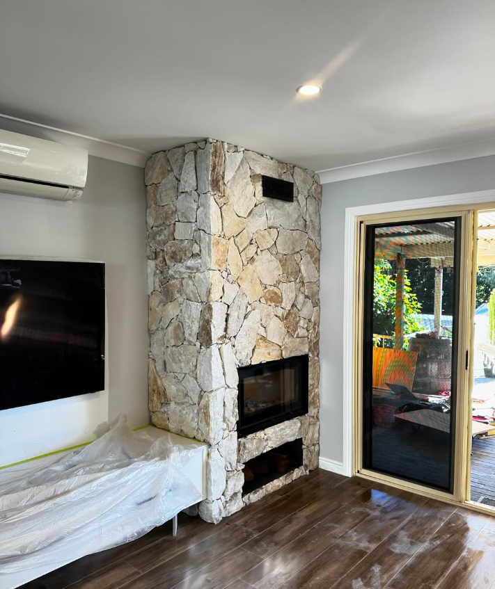 Natural stone clad fireplace feature wall in a living room